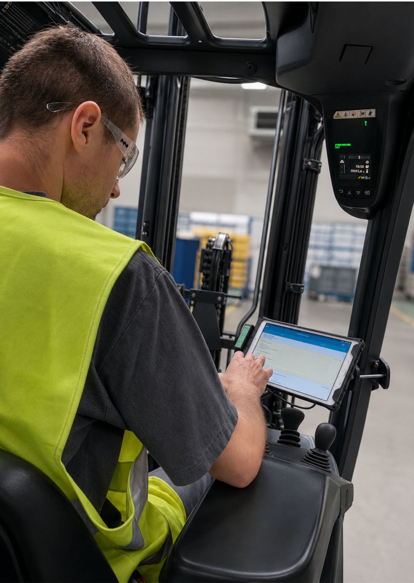 Operator wózka widłowego obsługujący system Forkfleet na terminalu w hali produkcyjnej
